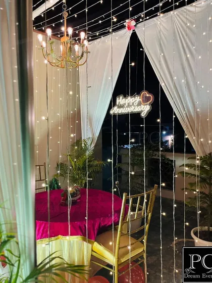 The romantic terrace cabana at night, illuminated by a chandelier and cascading fairy lights. This setup creates a magical and intimate atmosphere for a private celebration under the stars.