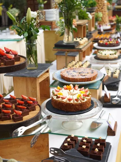 A beautiful dessert table from a Holi party, featuring a variety of cakes, tarts, and bite-sized sweets. We can create a full dessert spread to match the theme and scale of your celebration.