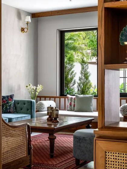 The living room features a traditional 'baithak' or window seat, creating a cozy and informal space for conversation.