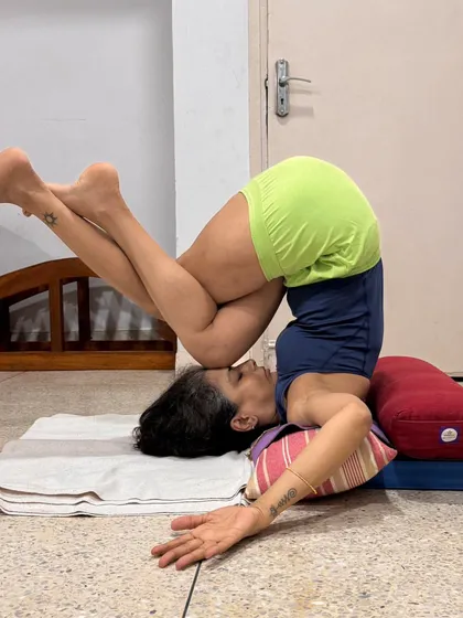 Garudasana (Eagle Pose) legs in Sarvangasana. The slight weight of the knee on the frontal brain helps to calm the mind. A virtuous asana is done from the heart, not the head.