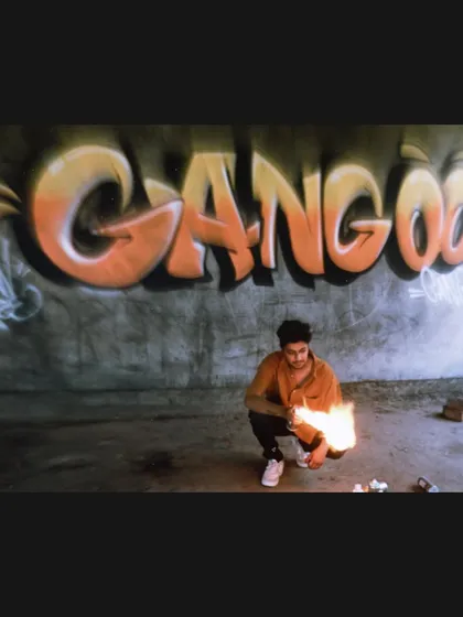 Setting the scene with fire for a music video shoot. The 'GANGOO' graffiti piece in the background adds a raw, powerful element to the visuals.