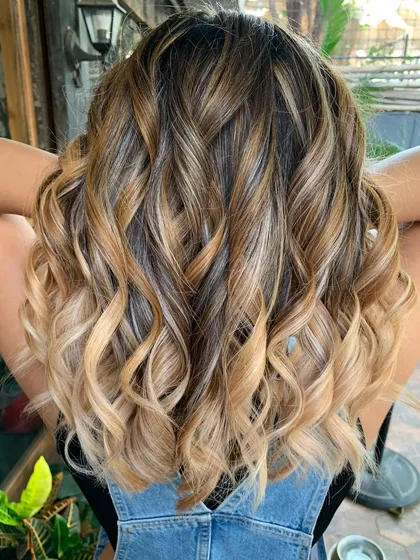 The perfect cookies and cream blend. I created this look by mixing warm caramel, vanilla, and ash blonde tones using a balayage technique. We used some bleach for the lighter ash blonde pieces to really make them stand out.