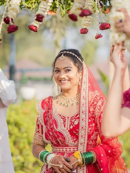 The bride's grand entrance under a floral canopy. Her makeup is radiant and picture-perfect.
