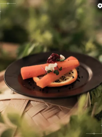 A minimalist plate of slow cooked carrots with chèvre, beetroot, and citrus. This dish celebrates the beauty of seasonal ingredients, where each component is allowed to shine.