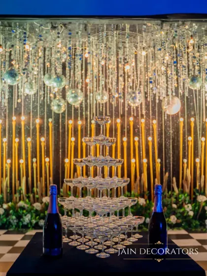 Celebrations are about the details that delight. A grand champagne tower becomes a shimmering centerpiece, set against a backdrop of cascading crystals and warm lights, promising a night of glamour and toasts.