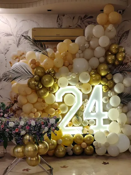 Another view of the 24th birthday balloon wall, complemented by a floral arrangement.