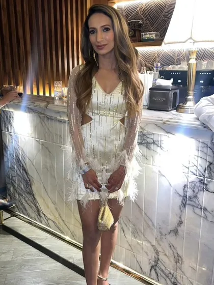 A full view of the custom ivory short dress, showing how the feather details on the hem and cuffs tie the whole look together. It's a fun, flirty, and sophisticated choice for a cocktail event.