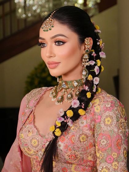 A close-up of the floral braid, showing how the colors of the flowers complement the bride's outfit and makeup.