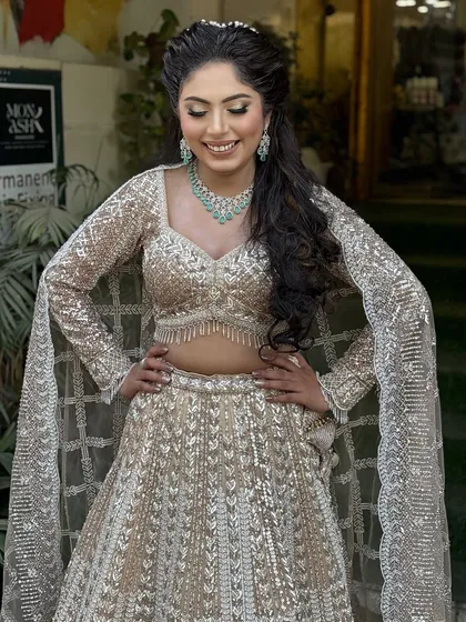 A full-length view of this sparkling engagement lehenga. The makeup is soft and glamorous, with a focus on defined eyes and glowing skin to match the outfit's shimmer.