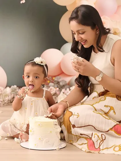 A first birthday is a milestone worth celebrating with joy and a little bit of mess. This mother and daughter cake smash session, set against a soft pastel balloon backdrop, captures the fun and sweetness of this special occasion.