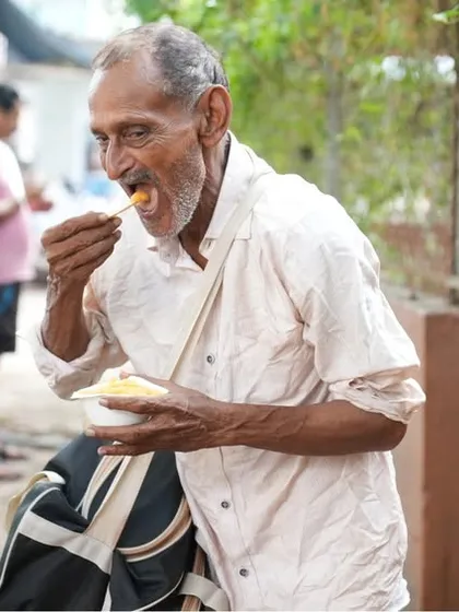 An elderly man finding nourishment and a moment of peace. Our seva aims to reach those who are most vulnerable, offering them care and respect.