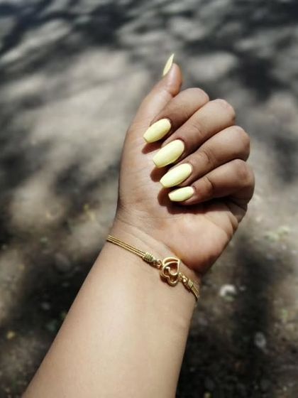 A simple and sunny pastel yellow gel polish on medium-length nails. This is a great color for summer or anytime you want a cheerful pop of color.