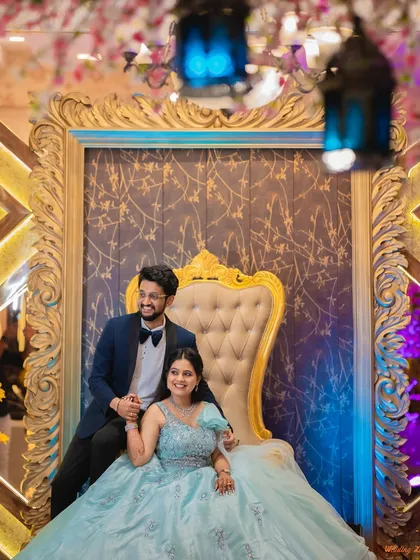 A regal portrait of Shraddha and Vivek seated on a throne-like chair at their engagement. This type of shot adds a touch of grandeur and formality to your photo album.