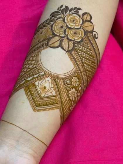 A creative use of negative space in this armband design. The empty circle provides a modern contrast to the traditional floral and geometric patterns around it.