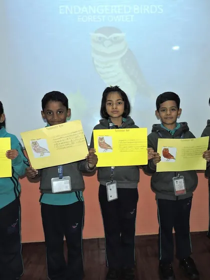 A group of students proudly display their completed projects on endangered birds, showing what they have learned about animal conservation.