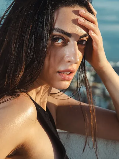 I love creating edgy, high-fashion looks for editorial shoots. This wet-look hair and glossy skin combination was achieved using specific products to give a fresh, out-of-the-ocean feel that holds up under direct sunlight for outdoor photography.