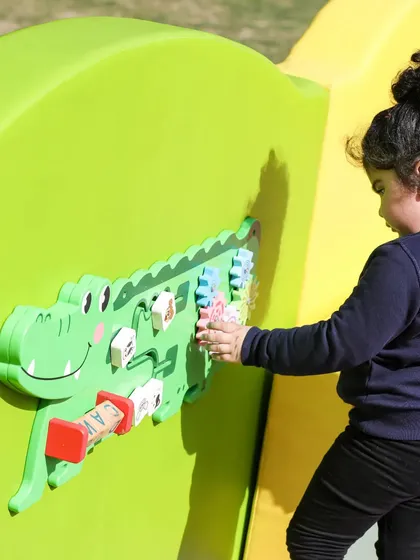 A close-up of our crocodile wall game, which helps develop hand-eye coordination with its interactive parts.