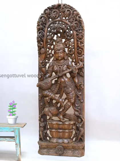 Our 72-inch masterpiece of the Goddess Saraswati, intricately carved with Jali (latticework) design. This large-scale wooden statue embodies wisdom and artistry, making it a profound centerpiece for any space dedicated to learning and culture.