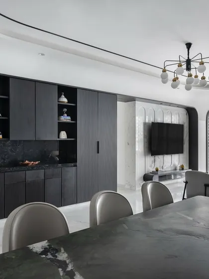 The dining and pantry area in 'The House of Arcs', where dark wood cabinetry with integrated arches provides a dramatic and functional backdrop.