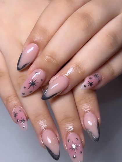 A celestial-inspired set with black French tips, star details, and sparkling silver accents.