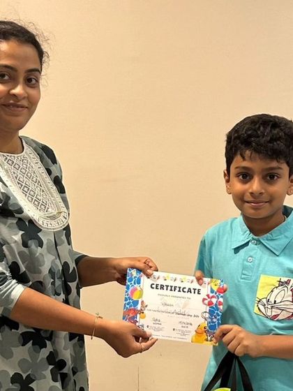 A happy camper receives his certificate after completing the first batch of our summer camp, celebrating his participation and effort.