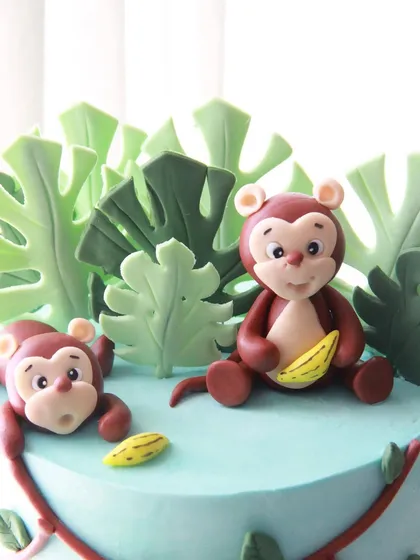 A detail shot of the monkey toppers, showcasing the care I put into crafting each character by hand.