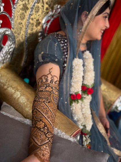 A side profile of Sonu, showing off her arm mehendi and beautiful smile.