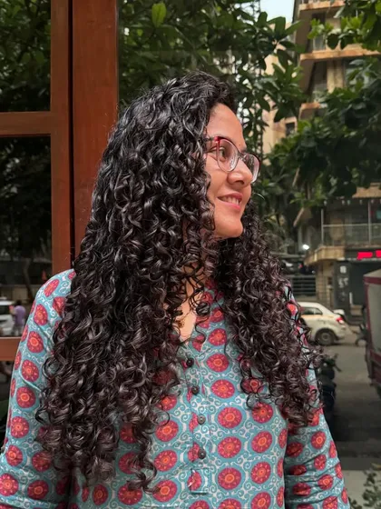 Absolute hair goals! This client's long, healthy, and defined curls are a testament to consistent care and the right haircut.