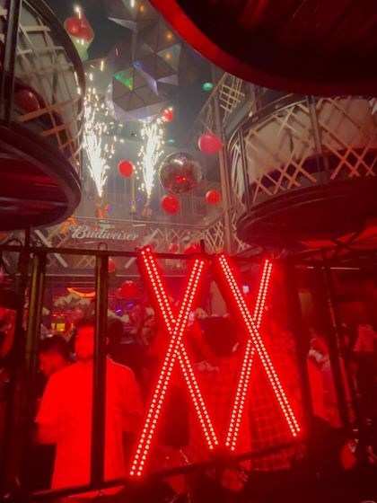 The sparklers add a celebratory feel to the intense red lighting of the club.