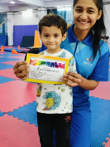 This young boy is delighted to receive his "Awesomeness" certificate from his coach.
