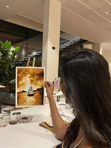 A participant admiring her coffee painting. These workshops are a great way to bond with friends or family.