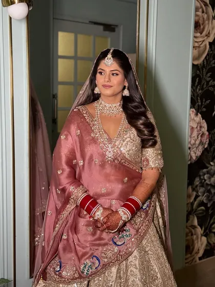 A full-length view of the bride, showing how the soft waves add a touch of modern elegance to her traditional wedding attire.