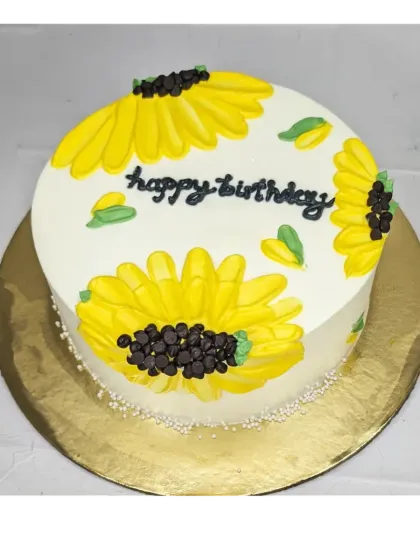 A bright and sunny sunflower cake. This chocolate truffle roasted almond cake is decorated with large, cheerful sunflowers made from buttercream.
