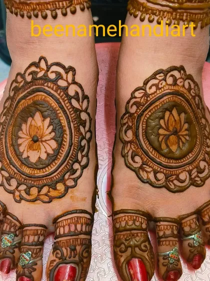 A beautiful foot mehandi with a central lotus mandala surrounded by a decorative border. The toes are also fully covered.