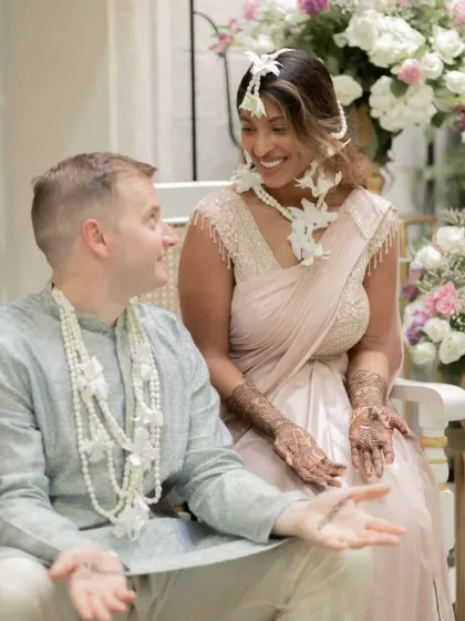 A happy couple sharing a moment during their mehndi ceremony, both adorned with my custom henna designs.