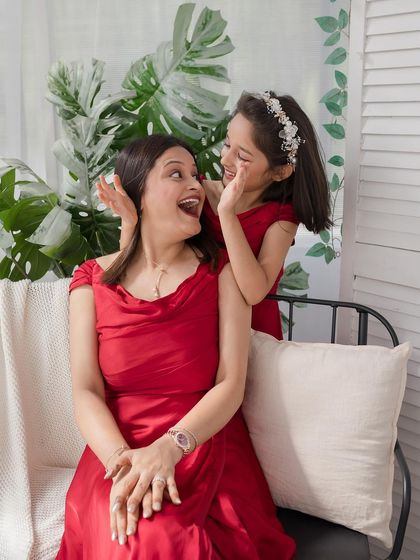 A playful moment between mother and daughter, their joy and love shining through.
