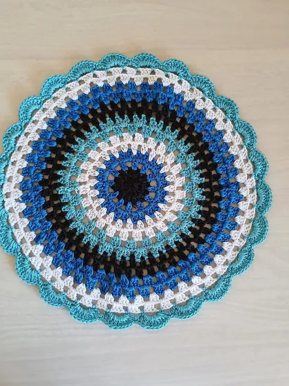 This elegant centerpiece features a mesmerizing pattern of concentric circles in shades of blue, black, and white. It's a modern design that can be customized in any color palette.