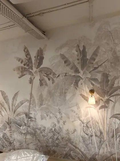 Here you can see my team member precisely installing a large-scale botanical mural in a commercial space. This sepia-toned jungle theme brings a sense of calm and nature into the work environment.