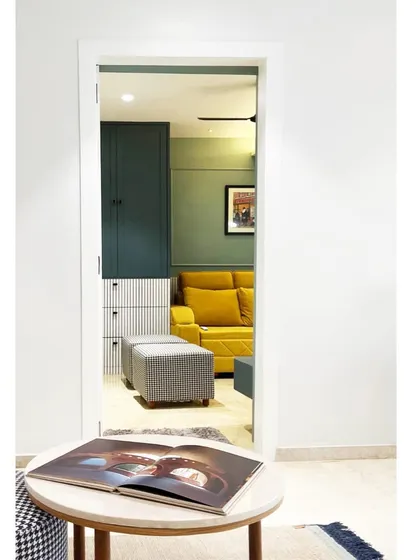 A glimpse from a minimalist white hallway into a vibrant media room. The contrast creates a sense of discovery and highlights the unique character of each space.