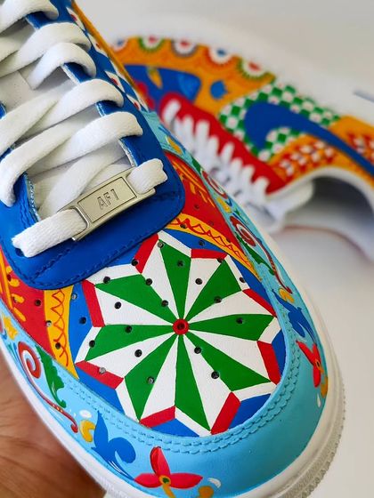 A close-up of the toe box on one of the mismatched Indian art sneakers. The detail work is what makes these pairs so special. Every line and dot is painted by hand to bring the complex design to life.