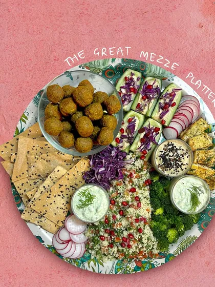 Meet The Great Mezze Platter. It’s a vibrant, generous spread designed for sharing and celebrating. I fill it with my signature green falafels, fresh tabbouleh salad, hummus-stuffed cucumber sticks, crispy lavash, and a creamy dill olive sour cream dip. It’s a complete Mediterranean food experience.