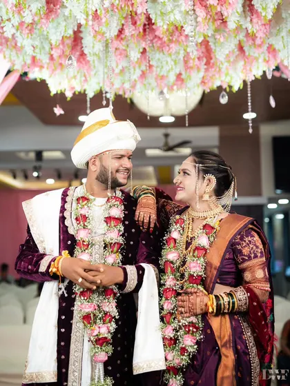 A classic portrait of the Marathi couple after their wedding. Their traditional attire and relaxed pose showcase their regal elegance.