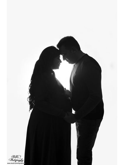 A romantic silhouette of a couple, their profiles outlined against a pure white background. This artistic shot captures their intimacy in a simple and powerful way.