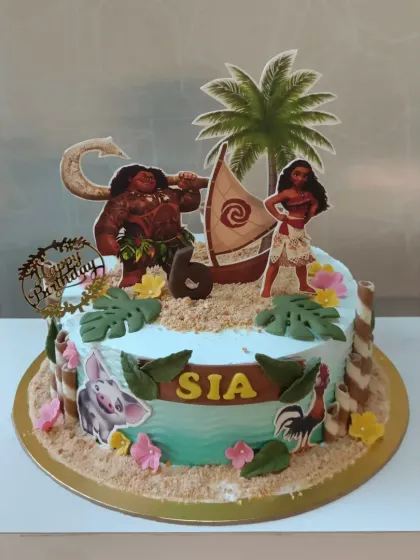 A Moana-themed cake that will transport you to the island of Motunui. It features characters like Moana and Maui, set against an ocean-blue cake with edible sand.