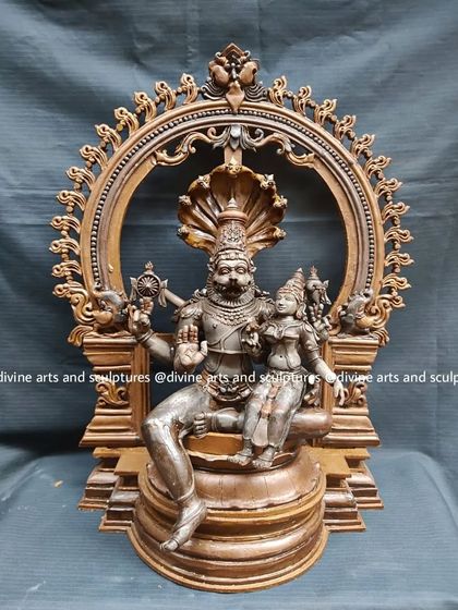 A wax model of Lakshmi Narasimha, framed by an ornate Prabhavali (arch). The entire composition, including the throne and archway, is created in wax for approval.