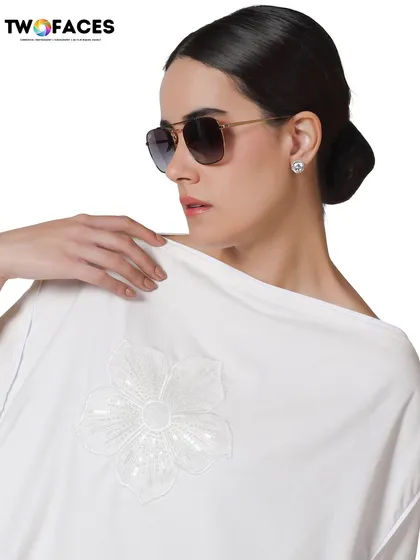 This shot features a model in a white top with sequin details, paired with sunglasses. It's a great example of a clean, commercial shot that works well for e-commerce and social media.
