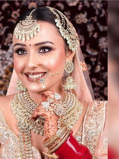 A happy bride wearing a beautiful champagne-gold Polki set with a matching passa. This is a complete, ready-to-wear look available for rent.