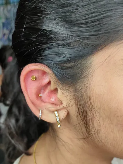 A healed ear with a flat piercing and a rook piercing. We advise on aftercare to ensure your piercings heal beautifully like this.