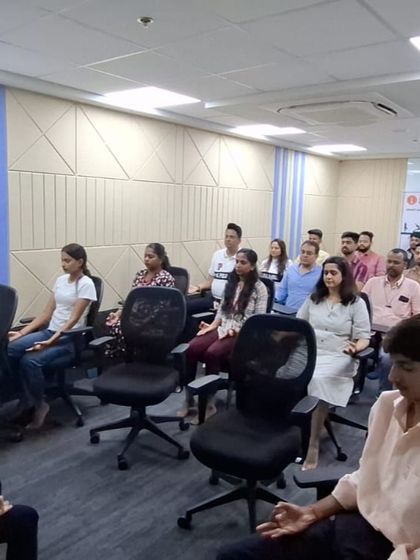 A wide shot of a corporate yoga session in progress. We can accommodate groups of various sizes, transforming a regular office space into a sanctuary of calm and well-being for a short while.
