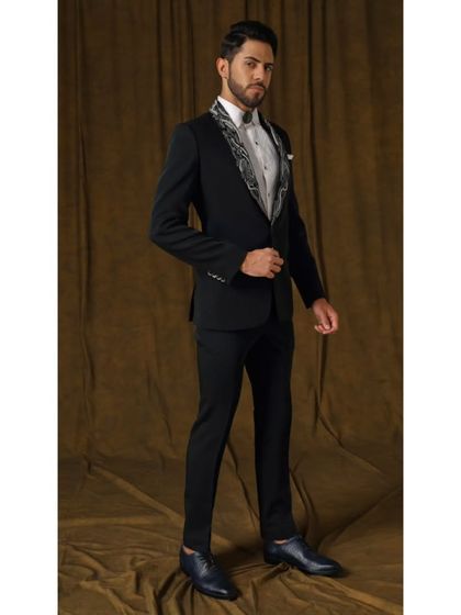 The Rud Avtar tuxedo, where nature's strength meets modern elegance. This piece features a shawl collar adorned with intricate chrome silver and grey embroidery, creating a masterpiece for the discerning gentleman.